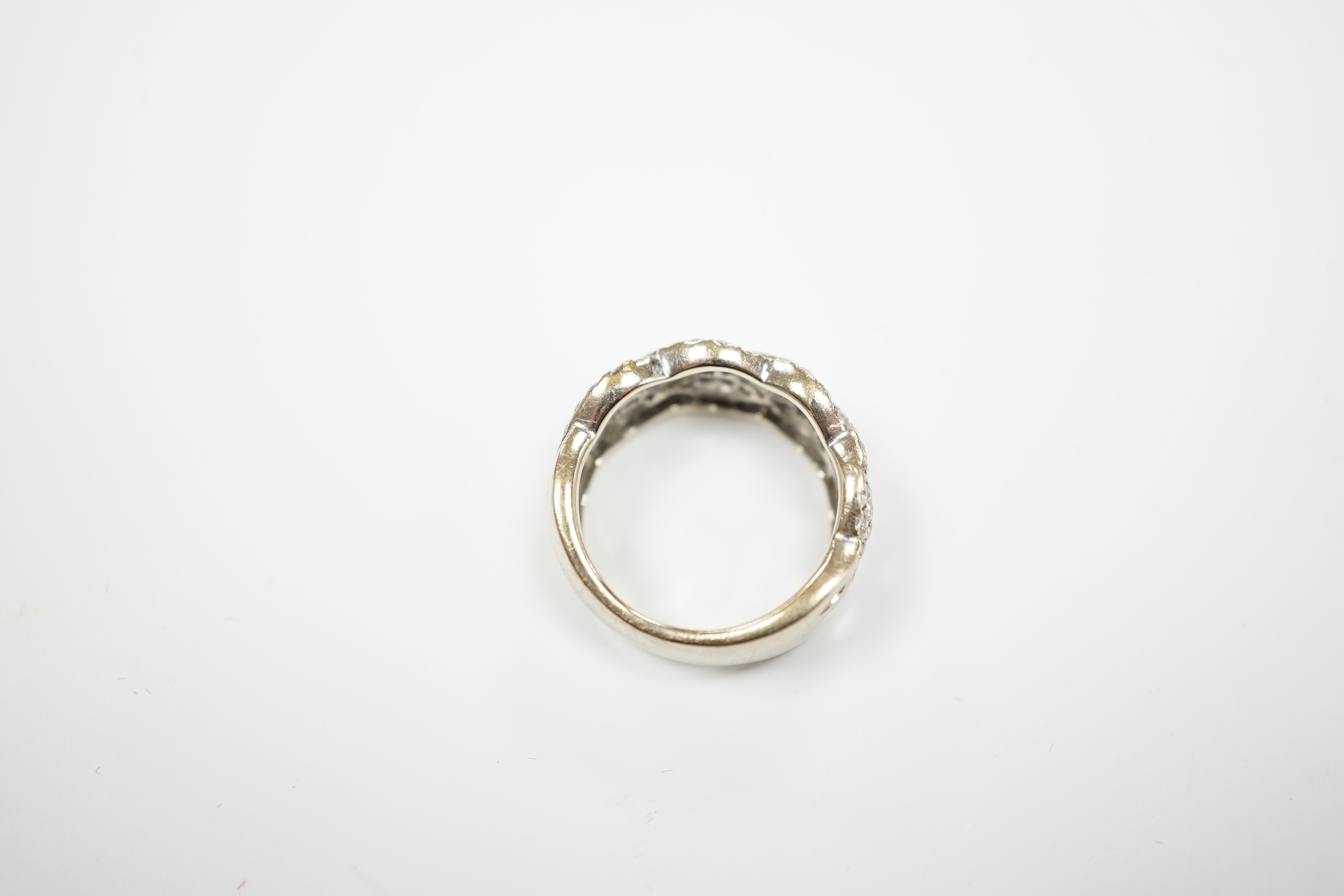 A modern 14k white metal and diamond chip cluster set dress ring, of interwoven design, size M, gross weight 6.4 grams.